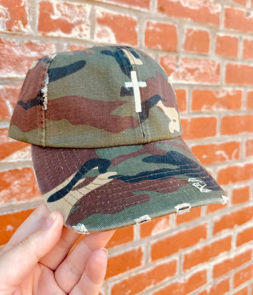 Distressed Camo Cross Hat - Style & Grace Co Distressed camo baseball hat with white embroidered cross on front"
"Christian cross camouflage cap with adjustable leather strap"
"Vintage style camo hat featuring faith-based cross design"
"Unisex distressed camo cross hat for casual and faith fashion"
"Faith-inspired camouflage baseball cap with worn look"
"Christian camo hat with embroidered white cross and brass buckle"
"Stylish religious camo cap with vintage distressed fabric"
"Adjustable camouflage